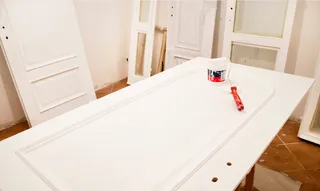 A picture of a door laid flat with paint brush on top of it in Asheville, NC.