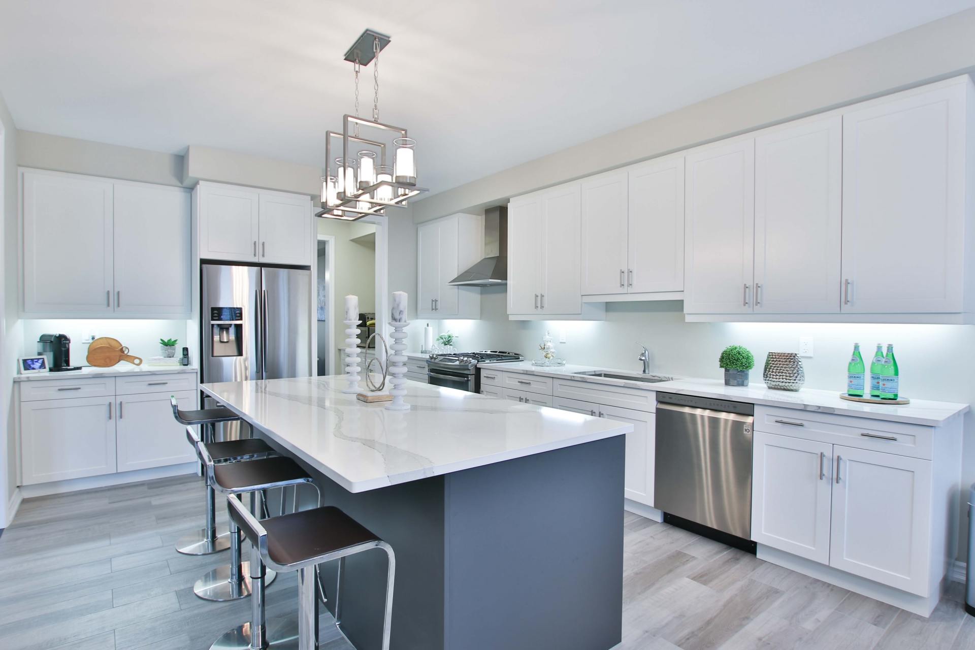A picture of a kitchen with white cabinets and white counter tops.